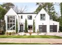 Striking modern home featuring a white facade, black framed windows, and well-kept landscaping at 1323 Ridge Rd, Raleigh, NC 27607