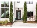 Elegant front entry with a decorative door, manicured shrubs, and a stone walkway at 1323 Ridge Rd, Raleigh, NC 27607