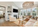 Bright living room with custom built-ins, fireplace, large windows, and a comfortable seating area at 1327 Gloriosa St, Apex, NC 27523