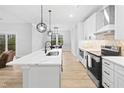 Modern kitchen with white cabinetry, quartz countertops, stainless steel appliances, and an island at 1423 Sagamore Dr, Louisburg, NC 27549