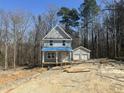 Two-story home with a front porch and a detached two-car garage in a wooded, under-construction lot at 1448B Maplewood Dr, Durham, NC 27704
