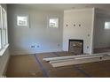 Bright living room with white walls, windows, and a fireplace, under construction at 1448B Maplewood Dr, Durham, NC 27704