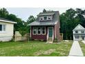 Charming two-story home with a modern metal roof, landscaped yard, and a welcoming entrance at 1448C Maplewood Dr, Durham, NC 27704