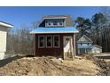 New construction home with wood siding, a covered porch, next to similar style new construction at 1448C Maplewood Dr, Durham, NC 27704
