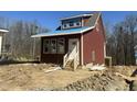View of new construction home with wood siding, covered porch, and landscaping work in progress at 1448C Maplewood Dr, Durham, NC 27704
