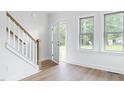 Inviting foyer with wood-look floors, a staircase, and an open door for ample natural light at 1448C Maplewood Dr, Durham, NC 27704
