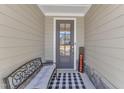 Inviting front porch featuring a welcome bench and a checkered rug at 163 Auburn Village Blvd, Raleigh, NC 27610