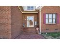 Welcoming front entrance with brick steps and classic wall sconces and flower decor at 1709 Shamrock Ln, Rocky Mount, NC 27804