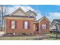 Charming brick home with burgundy shutters and manicured yard, with car parked on the side at 1709 Shamrock Ln, Rocky Mount, NC 27804