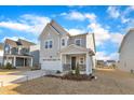 Attractive gray two-story home featuring stone accents, a two-car garage, and landscaped front yard at 1776 Golden Honey Dr, Wake Forest, NC 27587