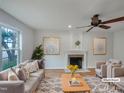 Bright living room featuring a fireplace, ceiling fan, hardwood floors, and comfortable seating at 1908 Mystic Dr, Durham, NC 27712