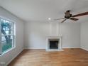 Bright living room featuring a fireplace, ceiling fan, and beautiful hardwood floors at 1908 Mystic Dr, Durham, NC 27712