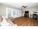Comfortable living room featuring wood flooring, a ceiling fan, and sliding glass doors at 2011 Quaker Lndg # 101, Raleigh, NC 27603
