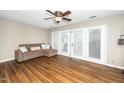 Cozy living room with wood floors, a ceiling fan, and access to the outdoor space at 2011 Quaker Lndg # 101, Raleigh, NC 27603