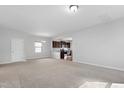Spacious living room with plush carpeting and an open floor plan leading to the kitchen at 2105 Attend Xing, Fuquay Varina, NC 27526
