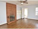 Spacious living room featuring a brick fireplace, hardwood floors, and built-in shelves at 215 Sallinger St, Knightdale, NC 27545