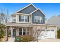 Charming two-story home featuring a two-car garage, covered porch with chairs, and neat front yard at 244 W Copenhaver Dr, Clayton, NC 27527