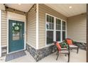 Inviting front porch with seating, stylish door with wreath, and neutral color palette at 244 W Copenhaver Dr, Clayton, NC 27527
