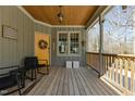 Relaxing front porch with wooden floors, yellow door, and charming decor at 3741 Manly Farm Rd, Wake Forest, NC 27587