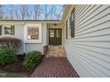 Inviting entryway with stone steps, brick walkway, and dark green double doors, surrounded by mature landscaping at 405 Lookout Pt, Rougemont, NC 27572