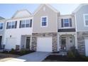 Inviting townhomes featuring stone accents, neutral siding, manicured landscaping, and attached garages at 5006 Tura St, Raleigh, NC 27610