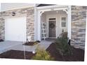 Covered front porch with seating and decor next to a one car garage at 5006 Tura St, Raleigh, NC 27610