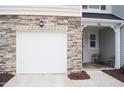 Attached one car garage with stone accents and cozy front porch with seating area at 5006 Tura St, Raleigh, NC 27610