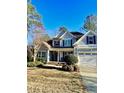Beautiful two-story home featuring a covered porch and attached garage with blue and gray exterior at 528 Opposition Way Way, Wake Forest, NC 27587
