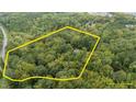 Secluded house surrounded by trees with an estimate of the property lines in yellow at 7101 Winding Way, Wake Forest, NC 27587