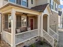Inviting front porch with stone accents, seating, and a charming red door at 7520 Channery Way, Raleigh, NC 27616