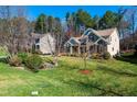 Well-maintained home with lush green lawn and mature trees, showcasing a blend of traditional and modern architectural elements at 805 Clausun Dr, Durham, NC 27713