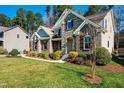 Elegant home with stone and brick accents, featuring a covered front porch and professionally landscaped yard at 805 Clausun Dr, Durham, NC 27713