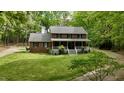 A two-story brick home with a inviting front porch, surrounded by lush trees and green lawn at 1013 Traders Trl, Wake Forest, NC 27587