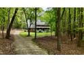 Charming brick home with a welcoming front porch and a long driveway through a lush green forest at 1013 Traders Trl, Wake Forest, NC 27587