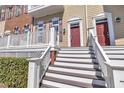 Close-up of a townhome entrance featuring a front porch, steps, and landscaped bushes at 10510 Sablewood Dr # 108, Raleigh, NC 27617