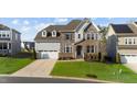 Beautiful two-story home showcasing stone, brick, and siding accents, a two-car garage, and a well-maintained front yard at 112 Ava Ct, Holly Springs, NC 27540