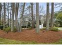 Lovely view of the home situated amongst mature trees and lush landscaping at 113 Preston Pines Dr, Cary, NC 27513