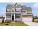 Charming two-story home with stone accents and a well-manicured front lawn at 11412 International Dr, Middlesex, NC 27557