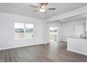 Sunlit living room with hardwood floors, ceiling fan, and sliding glass doors to outdoor space at 11412 International Dr, Middlesex, NC 27557