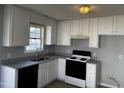 Updated kitchen featuring white cabinets, granite countertops, and black appliances at 128 Glengariff Ln, Clayton, NC 27520