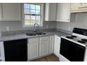 Updated kitchen featuring white cabinets, granite countertops, and black appliances at 128 Glengariff Ln, Clayton, NC 27520