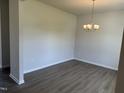 An empty dining room featuring hardwood flooring, neutral paint, and a modern chandelier at 131 E Victory View. Ter, Smithfield, NC 27577