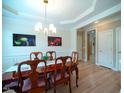 Elegant dining room featuring hardwood floors and a stylish chandelier above a wooden table at 13121 Sargas St, Raleigh, NC 27614