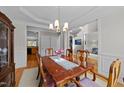 Formal dining room featuring hardwood floors, a large table, and views into other living spaces at 13121 Sargas St, Raleigh, NC 27614