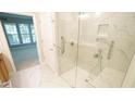 Modern bathroom features a glass-enclosed shower with bench, shower bar, and sleek white tile at 136 Sabiston Ct, Cary, NC 27519