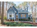 Charming blue home with bay window, wooden shutters and brick walkway surrounded by landscaping at 1617 Jenkins Rd, Wake Forest, NC 27587