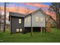 Back exterior view of home showcasing a deck, white siding, and well-maintained backyard at 1911 Stadium Dr, Durham, NC 27705