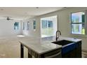 Open-concept living space with large windows providing ample natural light and backyard views from the kitchen island at 1912 Harrell Cove Ct # 171 Gunnison Cr, Fuquay Varina, NC 27526