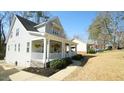 Side view highlighting the home's architecture and inviting porch, complemented by green landscaping at 206 Pine St, Fuquay Varina, NC 27526