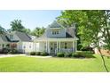 Beautiful home with a cozy front porch and lush green lawn at 206 Pine St, Fuquay Varina, NC 27526